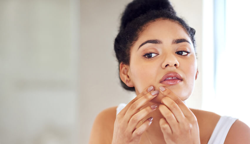 A women uses her two index fingers to apply pressure to the face